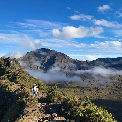 A single hiker walking along a rocky ridge